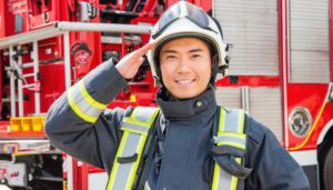 消防車の前で敬礼する消防士