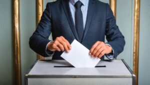 投票箱に投票用紙を入れる男性