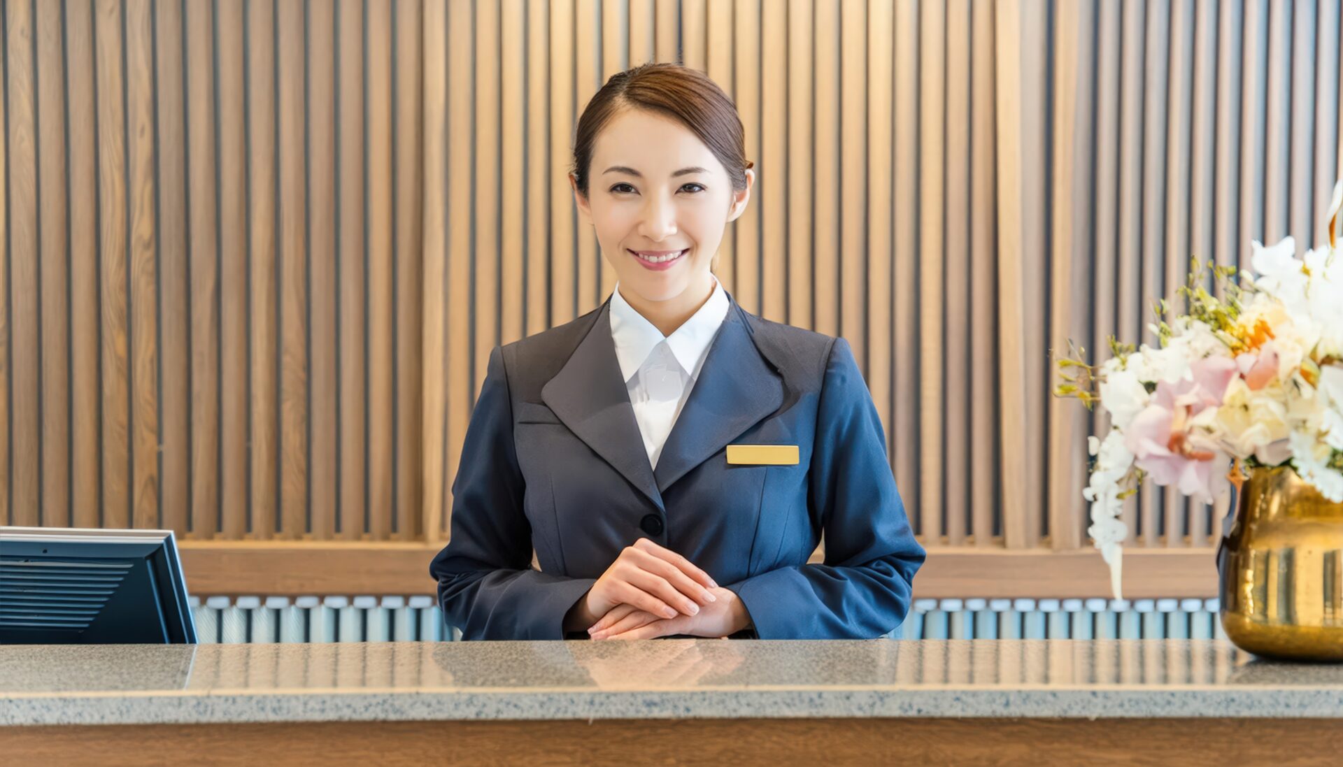 フロントデスクに立つ笑顔の女性スタッフ