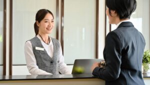 ホテルの受付でゲストに対応する女性スタッフ
