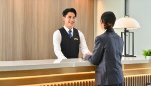 ホテルのフロントでゲストに対応する男性スタッフ
