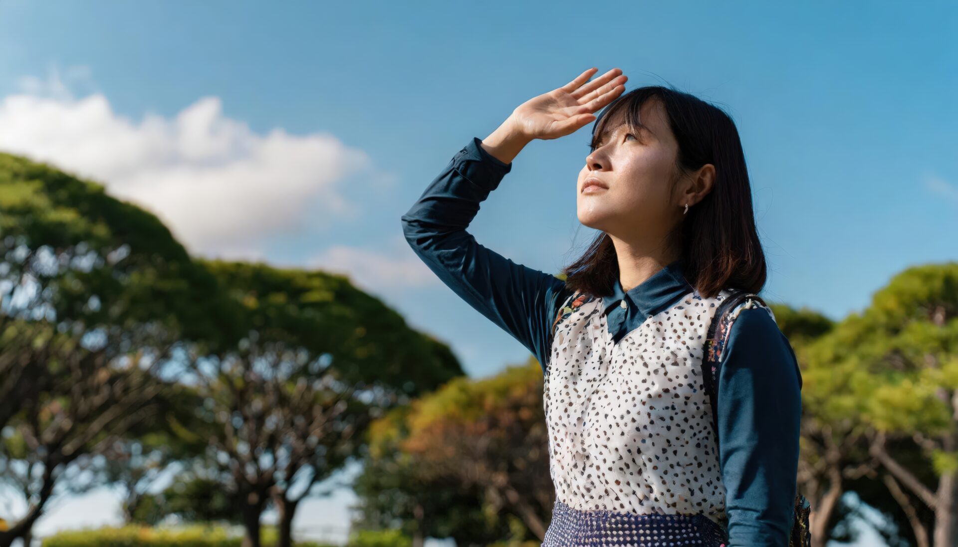 公園で空を見上げる女性