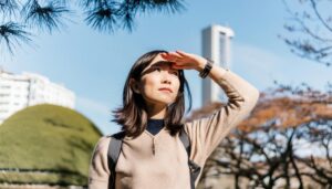 都会の空の下で遠くを見つめる女性