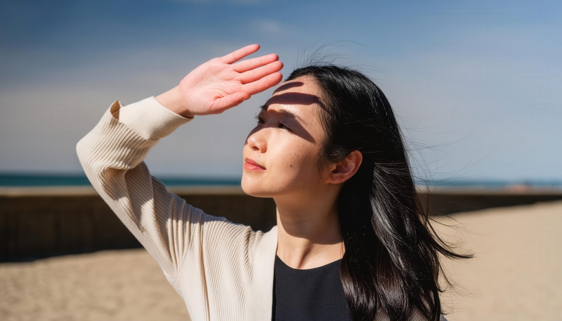 砂浜で日差しを浴びる若い女性