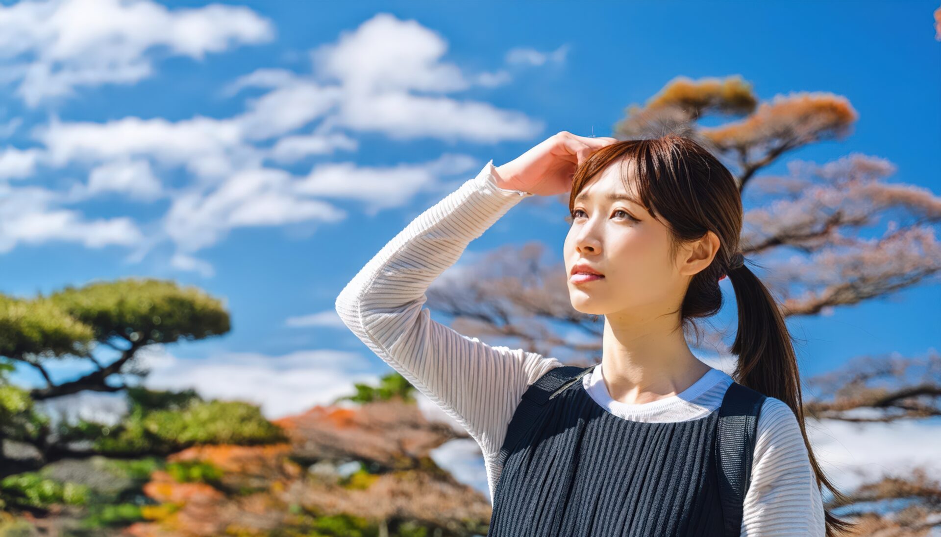 日本庭園で空を見上げる女性