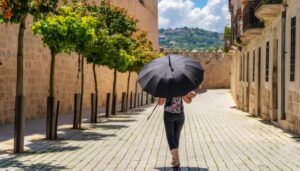 石畳の通りを日傘で歩く女性