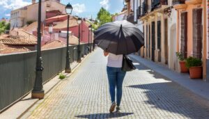 ヨーロッパの街路を日傘で歩く女性