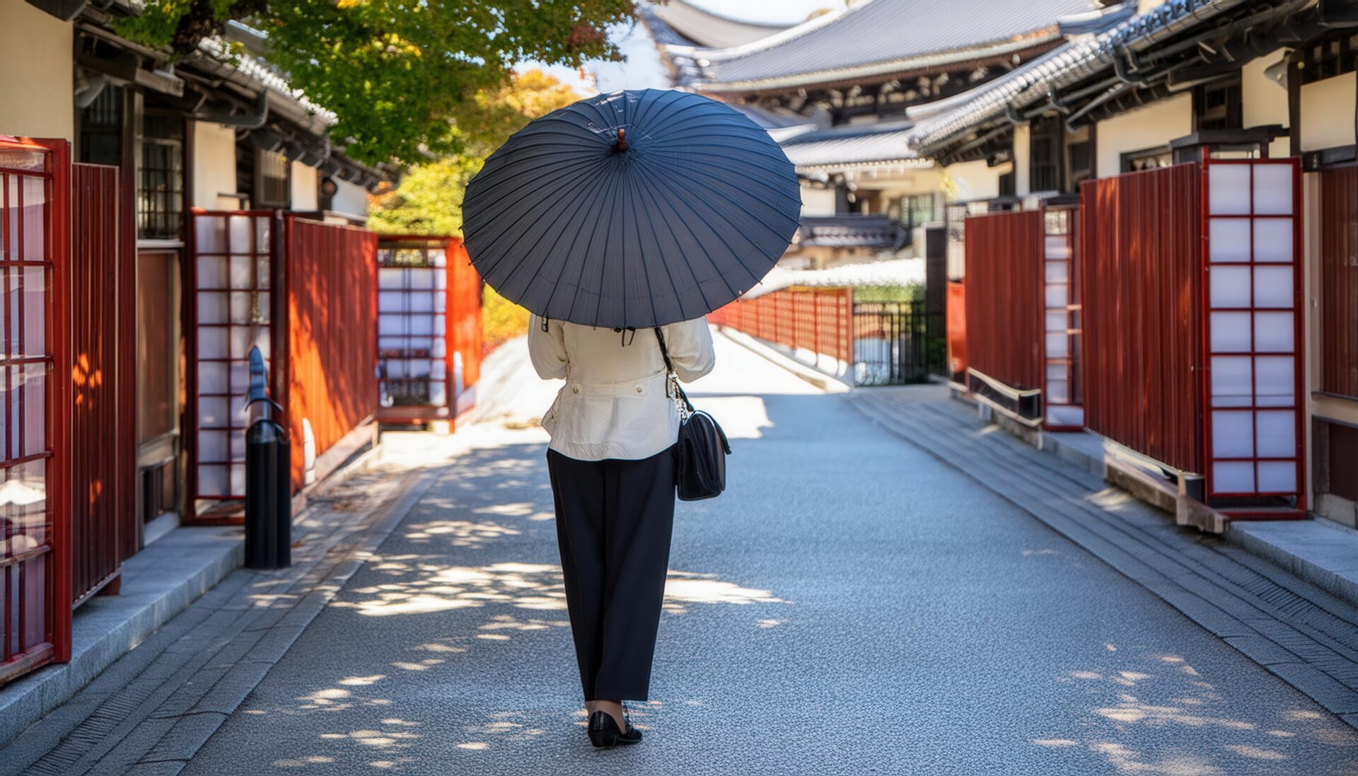 和風建築の街道を日傘で歩く女性