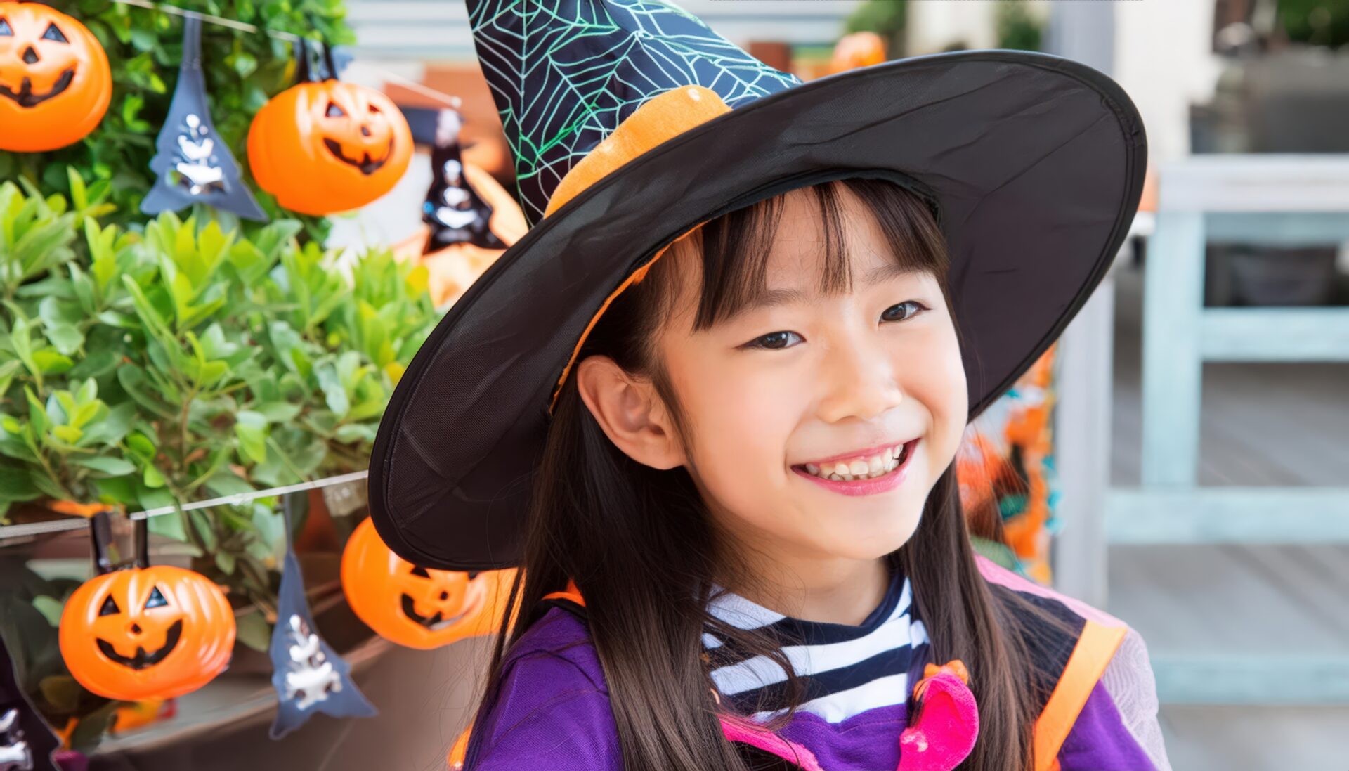 ハロウィンの飾りと魔女の仮装をした子供
