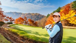紅葉のゴルフ場でポーズをとる男性