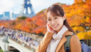 紅葉の前で笑顔の女性