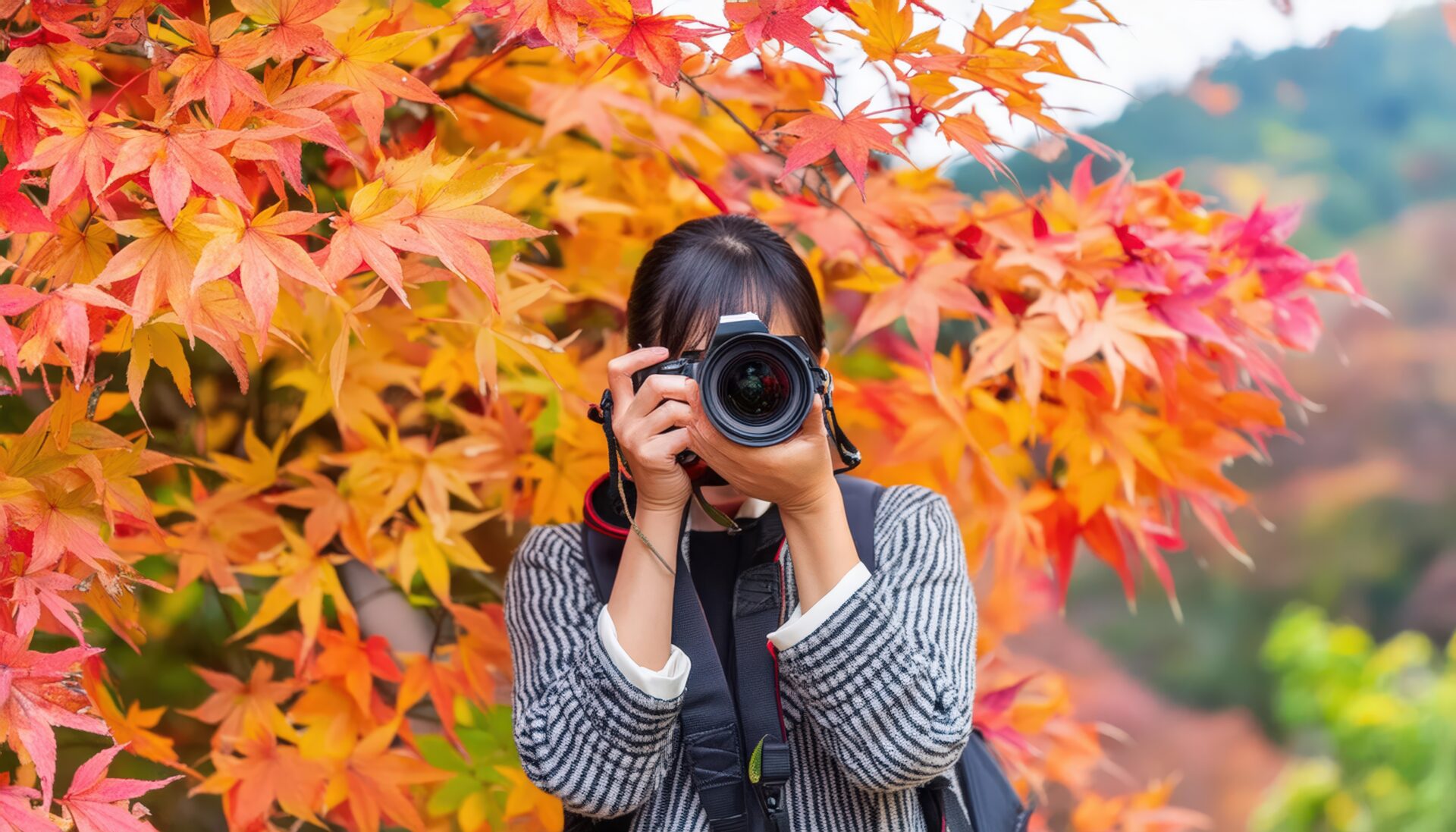 カメラを構える紅葉を背景にした女性