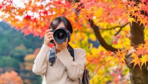 紅葉の中でカメラを構える女性