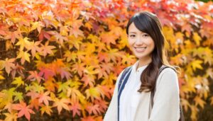 紅葉を背景にした女性の笑顔