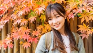 木の板塀と紅葉を背景にした女性
