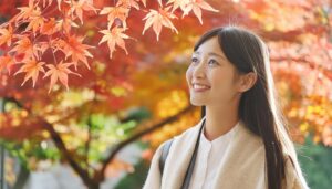 鮮やかな紅葉を見上げる女性