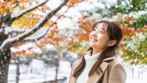 冬の木々を背景に微笑む女性