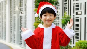 サンタクロースの衣装を着た笑顔の子供（屋外）