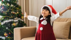 サンタクロース衣装の子供がポーズ（室内・ツリー）