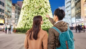 大きなクリスマスツリーを見上げるカップル