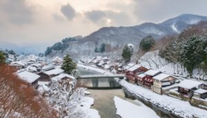 雪の降る川沿いの日本の町並み