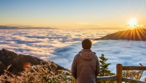 雲海と朝日を背景に佇む男性