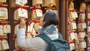 神社の絵馬を見上げる女性