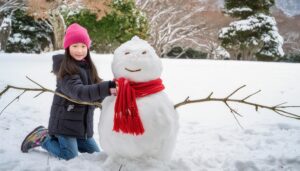 雪だるまと雪遊びをする少女