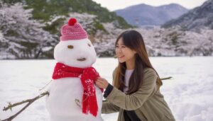 雪だるまと微笑む若い女性