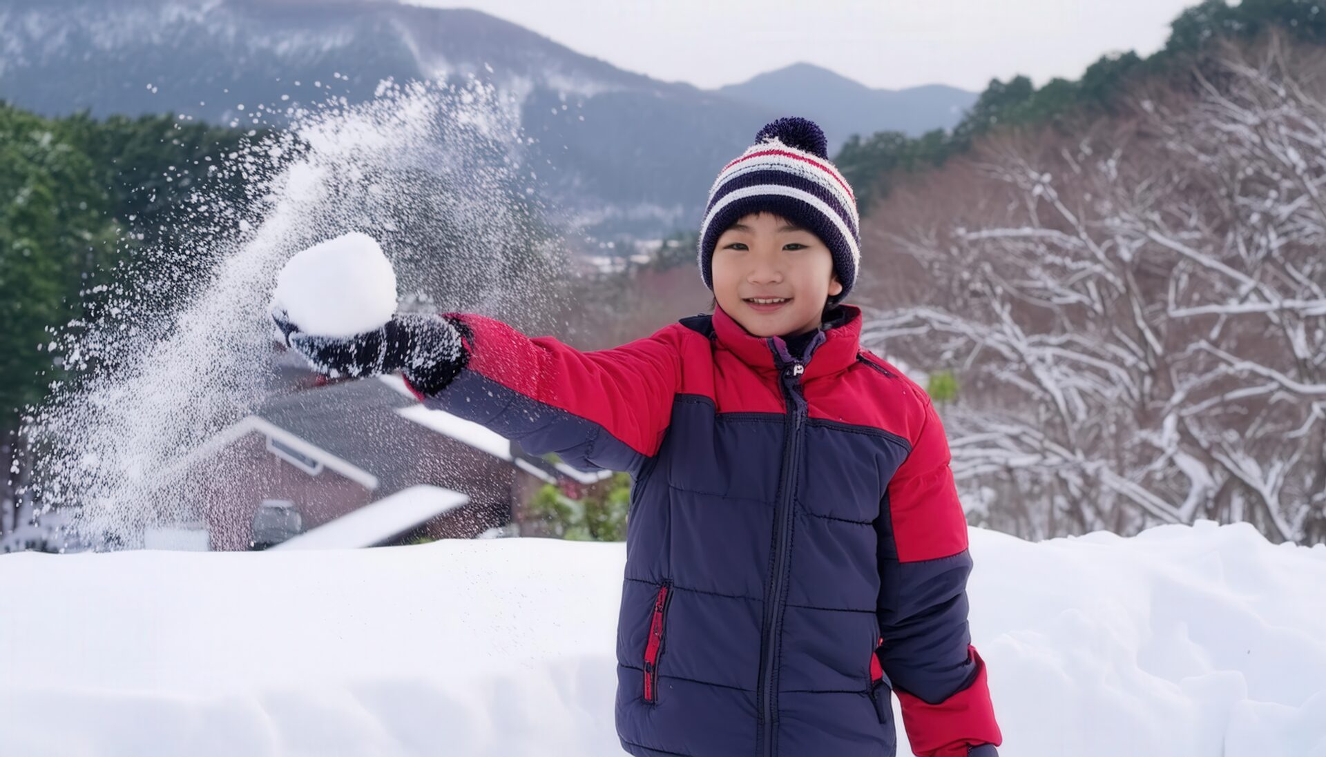 雪玉を持って笑顔の男の子