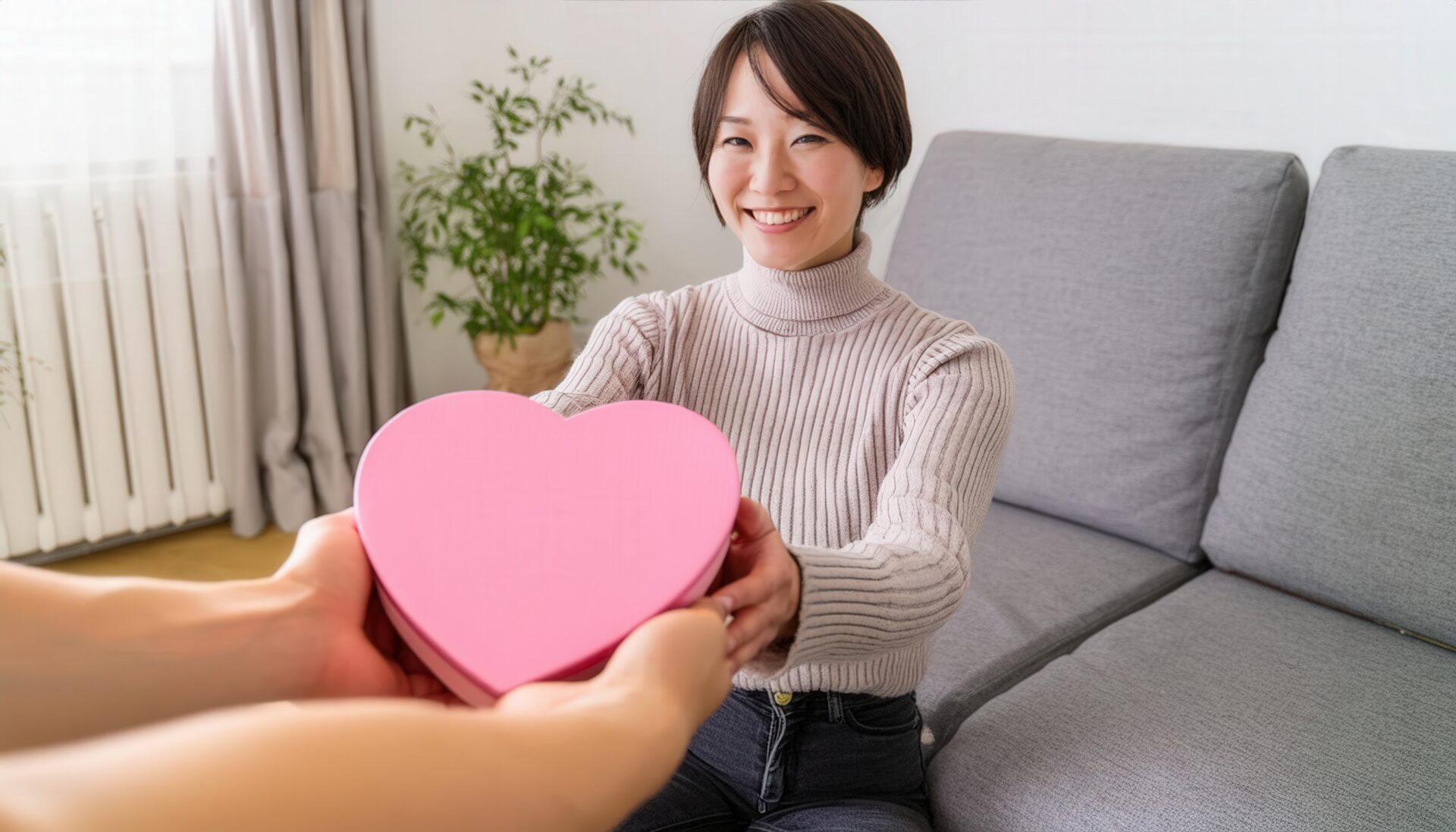 ピンクのハート型ボックスを渡す女性