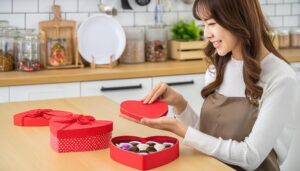 ハート型の赤いボックスを開けるエプロン姿の女性