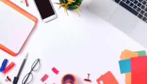 オフィス小物が並ぶ白い背景のフラットレイ