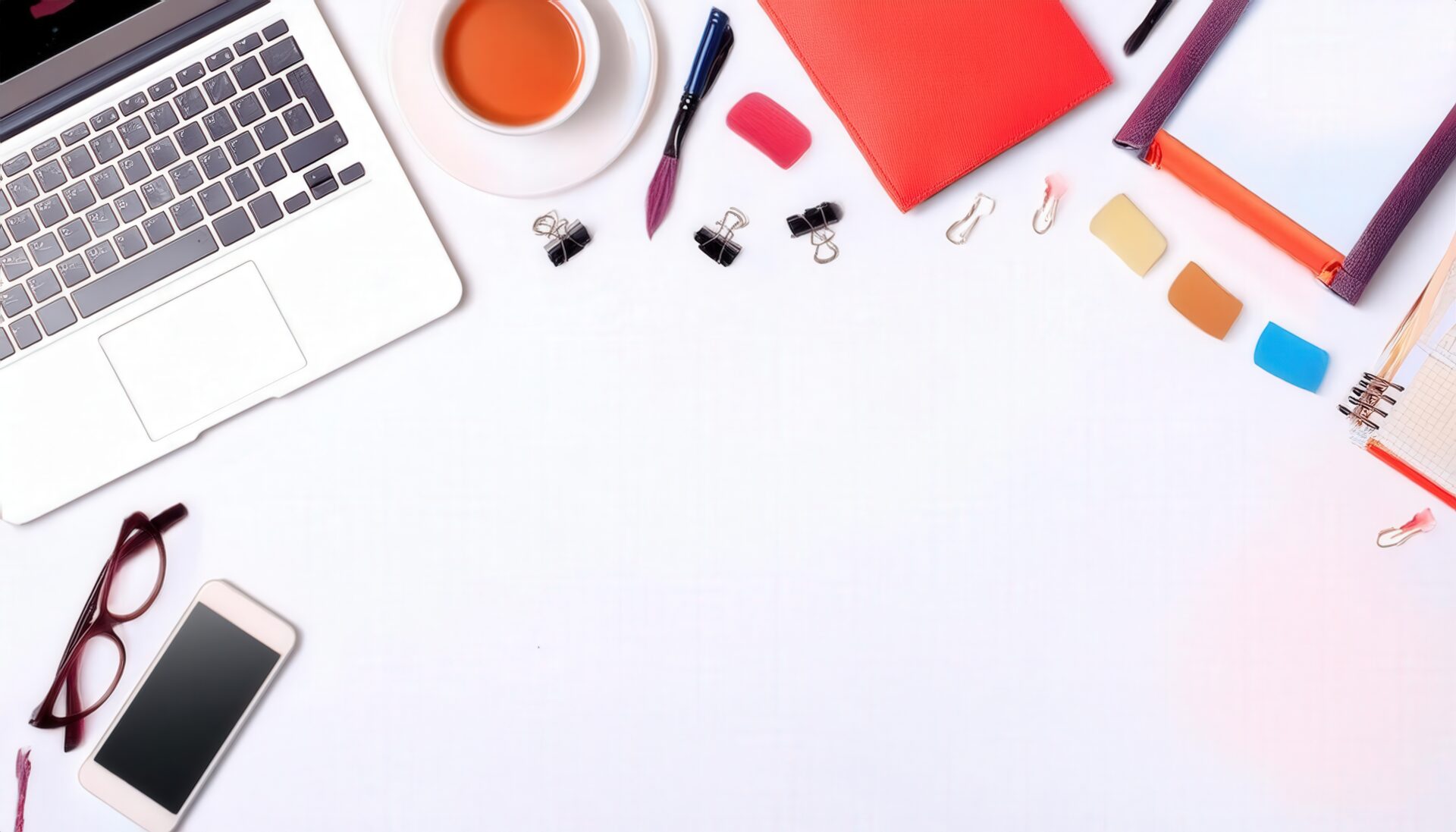 ノートパソコンと紅茶が並ぶ白い背景のフラットレイ