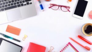 ノートパソコンとコーヒーが並ぶ白い背景のフラットレイ