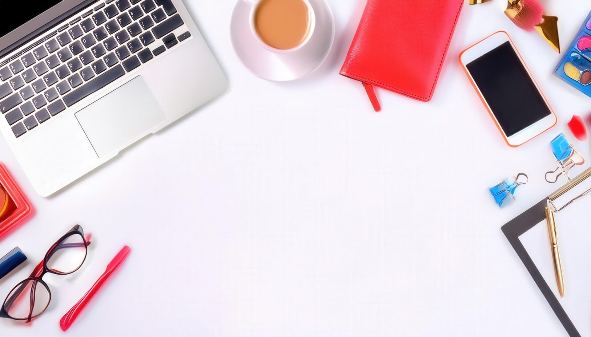 ノートパソコンとクリエイティブ小物が並ぶ白い背景のフラットレイ