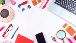 ノートパソコンとノートが並ぶ白い背景のフラットレイ