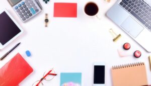 ノートパソコンとコーヒーカップが並ぶ白い背景のフラットレイ