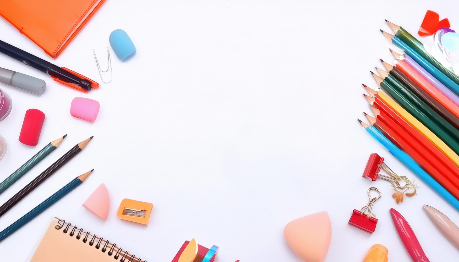 文房具とカラフルな鉛筆が並ぶ白い背景のフラットレイ