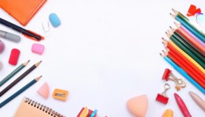 文房具とカラフルな鉛筆が並ぶ白い背景のフラットレイ
