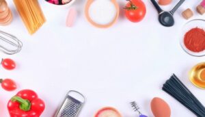 赤いパプリカとパスタが並ぶ白い背景のフラットレイ