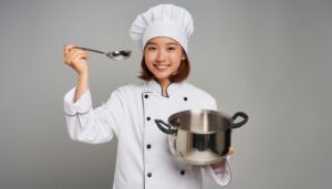 鍋を持つ笑顔の女性シェフ