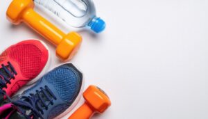 ダンベルとスポーツシューズのシンプルな構図
