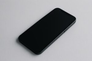 グレー背景のスマートフォン（電源オフ）