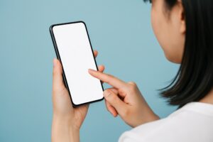 青背景でスマートフォンを操作中の女性（横向き）