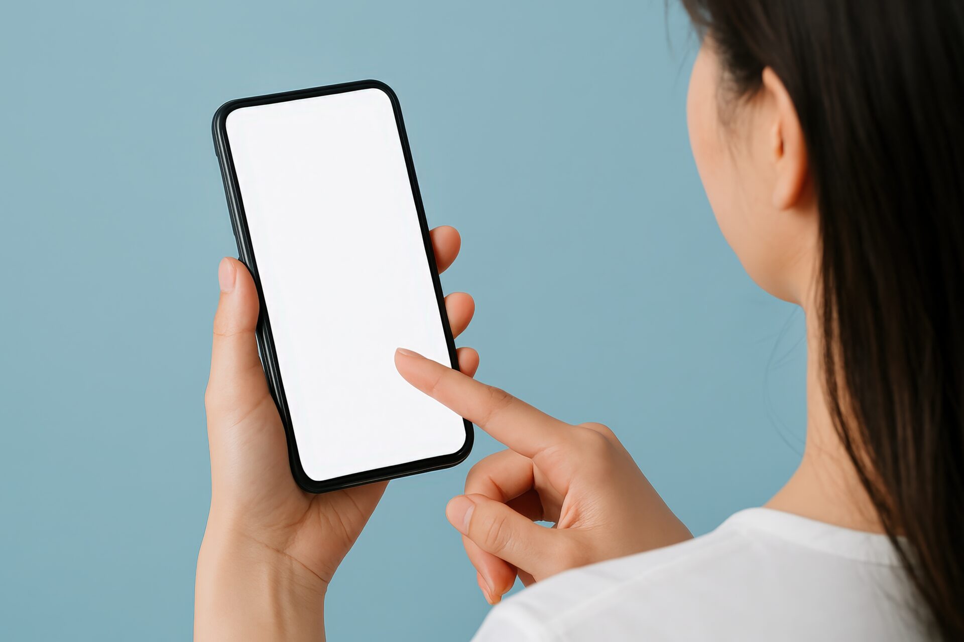 青背景でスマートフォンを操作する女性（横顔）