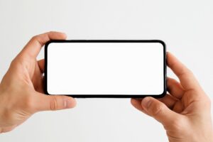スマートフォンを横向きに持つ手（明るい背景・画面モックアップ）