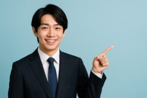水色背景で指差すスーツ姿の若い男性