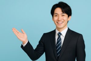 水色背景で片手を上げて案内するスーツ姿の若い男性