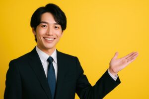 黄色背景で片手を上げて案内するスーツ姿の若い男性